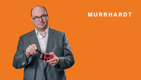Armin Mößner kurbelt an einem roten Kurbelradio