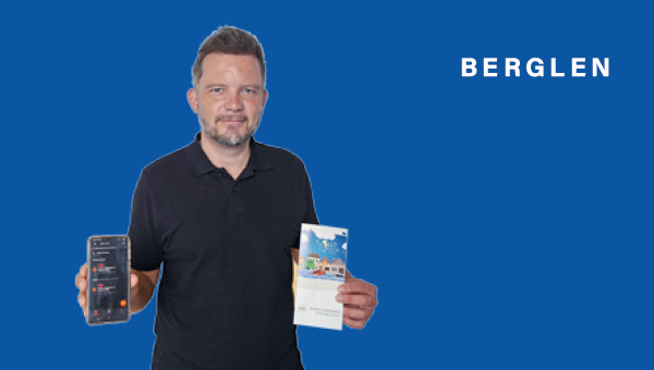 Holger Niederberger zeigt Handy und Flyer in die Kamera