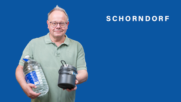 Bernd Hornikel hält eine Flasche Wasser und einen Henkelmann in die Kamera
