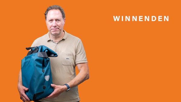 Hartmut Holzwarth hält einen großen, blauen Rucksack in den Armen
