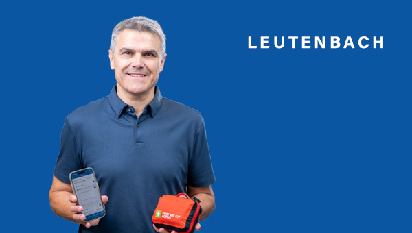Jürgen Kiesl präsentiert ein Erste-Hilfe-Set und ein Handy mit der NINA-App